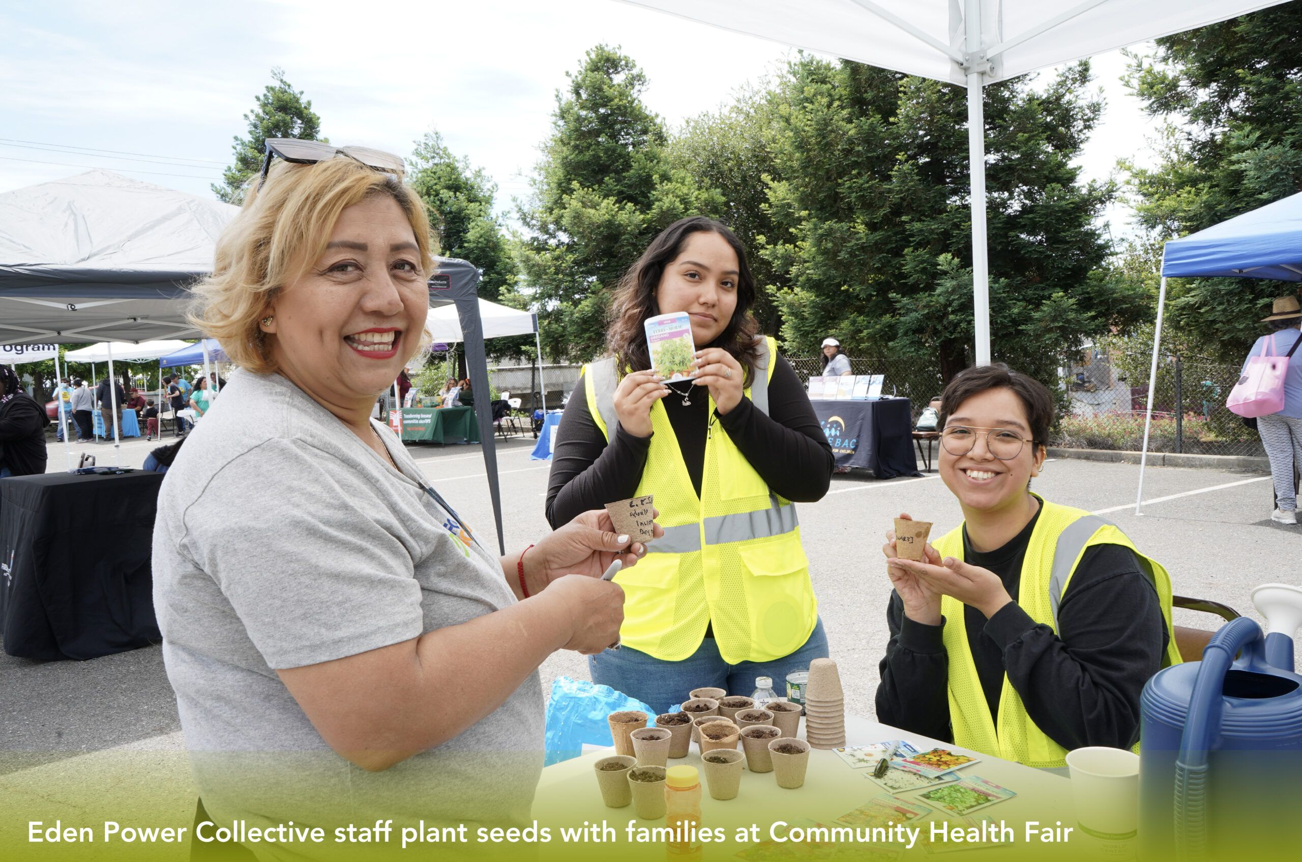 Eden Power Collective staff plant seeds with families at Community Health Fair